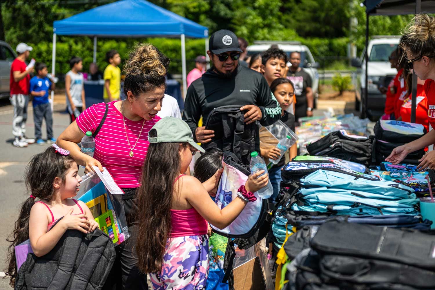 Community members receiving backpacks at a City of Hope event